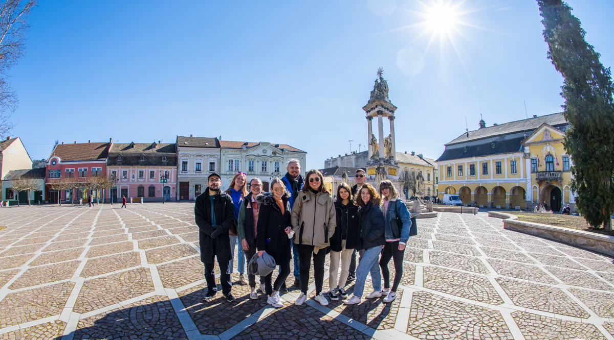 Group holding flag on hilltop.